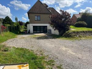 a house with a garage on a gravel driveway at Le Bibrou Appartement 2 chambres in Heuringhem