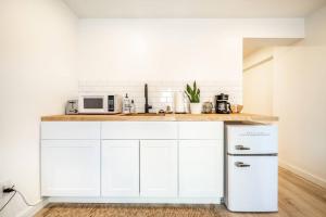 a kitchen with white cabinets and a white refrigerator at Brand New Studio Apartment in Great Neighborhood in Colorado Springs