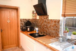 a kitchen with a counter with a sink and a stove at Audenshaw Spacious Double Room in Manchester +8 photos