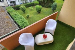 a balcony with two white chairs and a table at Gemütliches Loft 150 m von SLK klinikum Böckingen in Heilbronn