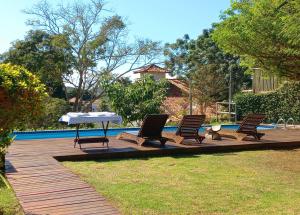 a patio with three chairs and a table next to a pool at Bossa Nova Búzios Pousada Home in Búzios +68 photos