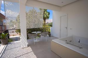 a bathroom with a tub and a table on a balcony at B&B Le Muse in Mondello