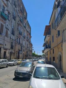 a group of cars parked on a street with buildings at La Petite Maison in Naples