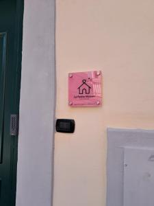 a pink sign on a door with a sign on it at La Petite Maison in Naples