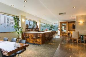 Un bar en un restaurante con mesas y sillas. en Luana Waikiki Oceanview High Floor Condo 1210, en Honolulu
