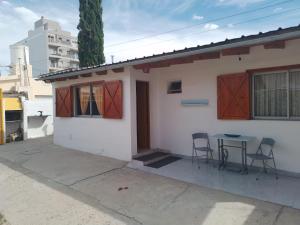 a small white house with a table and chairs at Alaia in Puerto Madryn