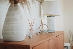 a wooden cabinet with two glasses and two vases on it at Sea & Rocks 15 - House in Lagoa +102 photos