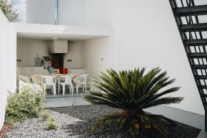 a house with a palm tree in the yard at Sea & Rocks 15 - House in Lagoa