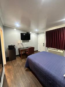 a hotel room with a bed and a desk at Travelers INN in West Sacramento