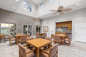 a dining room with tables and chairs and a kitchen at Mermaid Drive Vista Verde East 240 in St Petersburg
