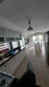 a large kitchen with white cabinets and a dining room at La beethoven YB in Yerba Buena +2 photos