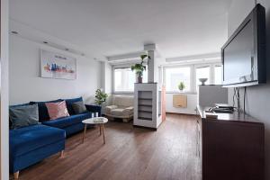 ワルシャワにあるCozy And Bright - City Center - Zgoda 13の青いソファとテレビのあるリビングルーム