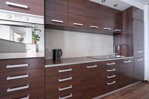 ワルシャワにあるCozy And Bright - City Center - Zgoda 13の木製のキャビネットとシンクを備えたキッチン