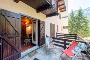 a porch with two chairs and an open door at Chaberton Romantic Retreat Ski In Ski Out - Happy Rentals in Claviere