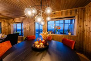 a dining room with a large wooden table with lights at Storefjell Resort - Panorama apartments in Gol