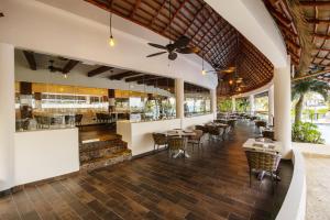 a restaurant with tables and chairs and a bar at The Reef Playacar Beach Resort & Spa-Optional All Inclusive in Playa del Carmen