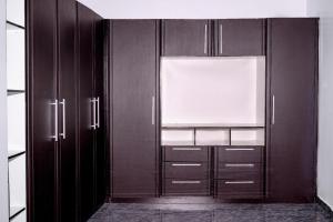 a kitchen with wooden cabinets and a window at Graceland Residence in Aja