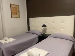 two beds sitting next to each other in a bedroom at Itaka in LʼAquila