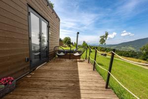 a deck with a table and chairs on a house at Aurora Green Hill in Podobin