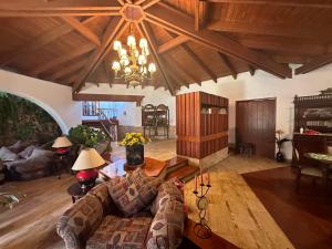 Una sala de estar con un sofá y una lámpara de araña. en Casa de Campo Condominio El Pueblo-Santa Clara,Ate, en Lima