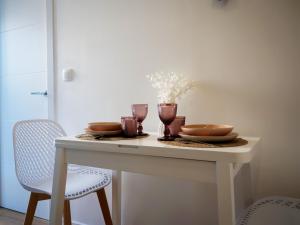a white table with plates and glasses on it at Luz Atlántica, centro de A Coruña in A Coruña