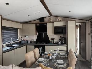 a kitchen with a table and chairs in a room at Beechwood 20 in Camber