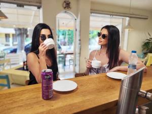 two women sitting at a table drinking coffee at Хотел ЗОНАРИТА in Primorsko