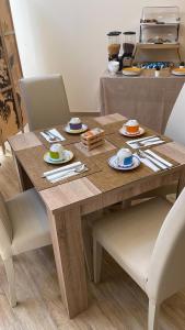einem Holztisch mit Tellern und Utensilien darauf in der Unterkunft Attic room in Neapel