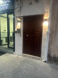 eine braune Tür an der Seite eines Gebäudes in der Unterkunft Attic room in Neapel