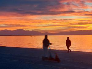 two people walking on the beach at sunset at LOBBY comfort studio in Thessaloniki