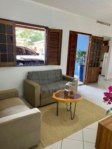 ein Wohnzimmer mit Sofa und Tisch in der Unterkunft Casa mobiliada em Viçosa do Ceará em condomínio in Viçosa do Ceará