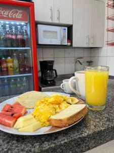 a plate of breakfast food and a glass of orange juice at Hotel Inter del Café in Pereira
