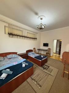 a bedroom with two beds and a table and chairs at STOP Hotel in Sheki