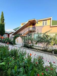 a garden in front of a building with flowers at STOP Hotel in Sheki