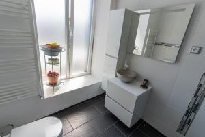 a bathroom with a toilet and a sink and a window at Cantinho do Bairro Alto in Alijó +29 photos