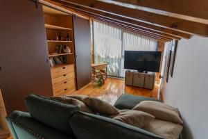 a living room with a couch and a television at Cantinho do Bairro Alto in Alijó
