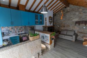 a kitchen with blue cabinets and a couch in a room at Cantinho do Bairro Alto in Alijó