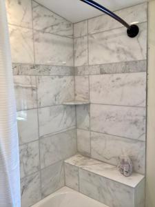 a bathroom with a shower with a white marble wall at Riva Loft with a View in Riva +22 photos