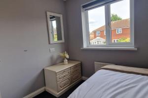 a bedroom with a bed with a dresser and a window at Liverpool House Near City Centre in Liverpool