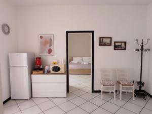 a room with a refrigerator and a mirror and a bed at Angolo Lamia Sicily Apartment in Partinico
