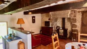 a living room with a stone fireplace and a table and chairs at La Meltiere Sleeps 4 with Garden in Courcité