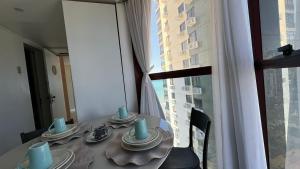 a dining table with a view of a building at Flat Golden Beach in Recife