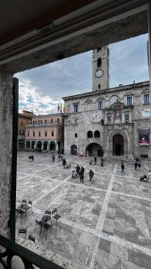 a large building with a clock tower in a courtyard at Suite Piazza del Popolo in Ascoli Piceno