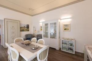 a dining room with a white table and chairs at Suite Piazza del Popolo in Ascoli Piceno