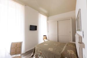 a bedroom with a bed and a tv on a wall at Suite Piazza del Popolo in Ascoli Piceno