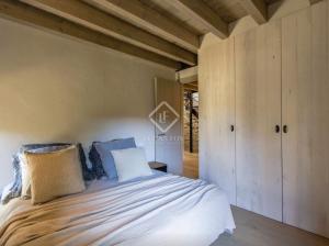 a bedroom with a large bed with blue pillows at Villa Age con chimenea in Age