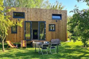 a small house with a table and chairs in the yard at Le petit nid des Mésanges in Volckerinckhove