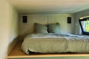 a bedroom with a bed in a room with a window at Le petit nid des Mésanges in Volckerinckhove