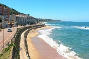 a view of a beach with buildings and the ocean at UMDLOTI House - Upper private level- Beach Road - LOCATION in Umdloti