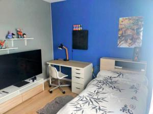 a bedroom with a bed and a desk with a computer at Maison de vacances spacieuse et lumineuse, proche Nantes et mer in Treillières